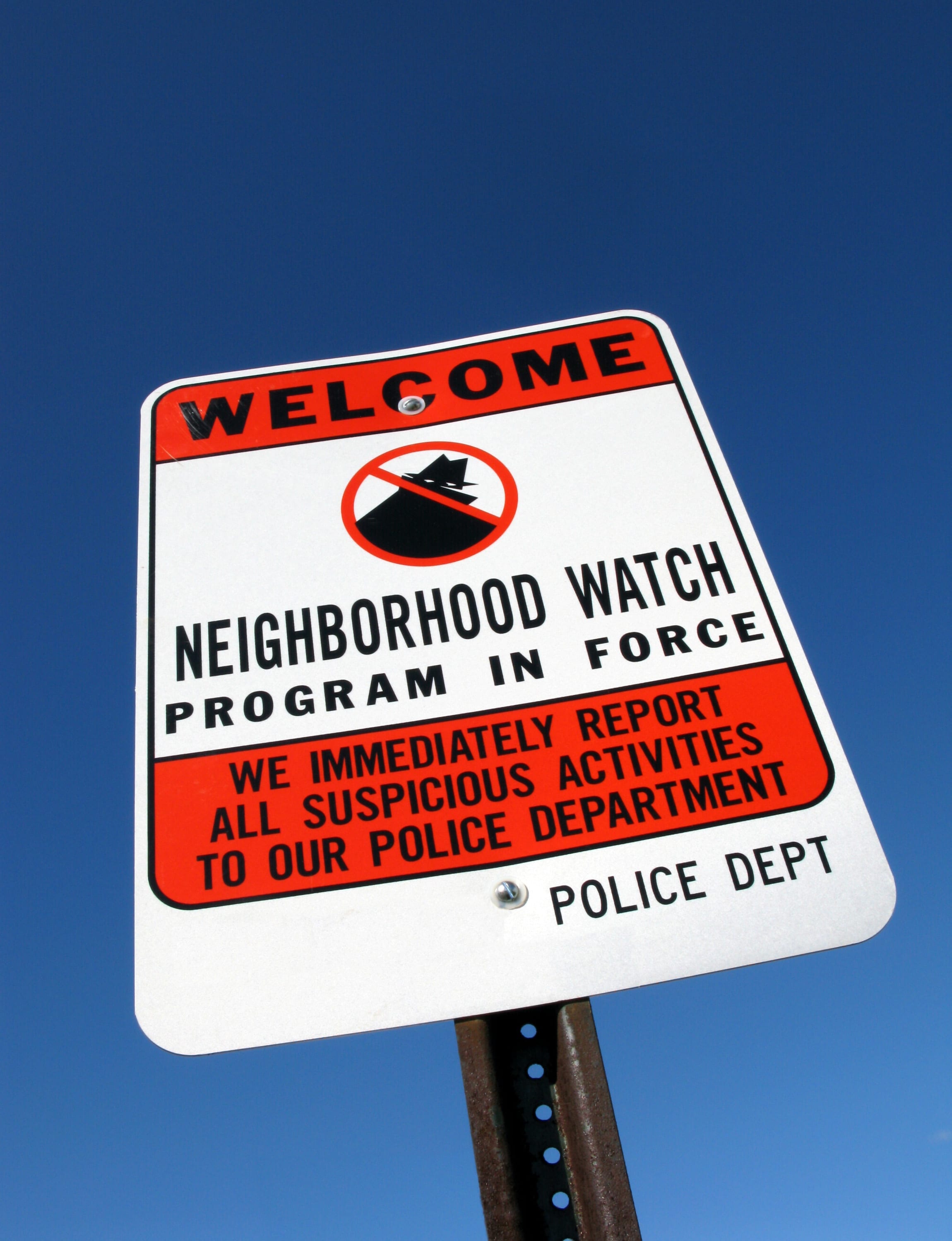 A Welcome Neighborhood Watch Program in Force sign against a clear blue sky.